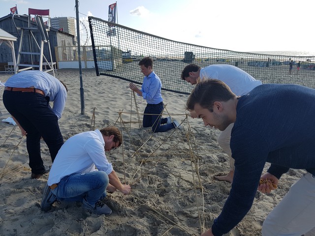 Teambuilding opdracht bamboe bouwen op het strand van zandvoort
